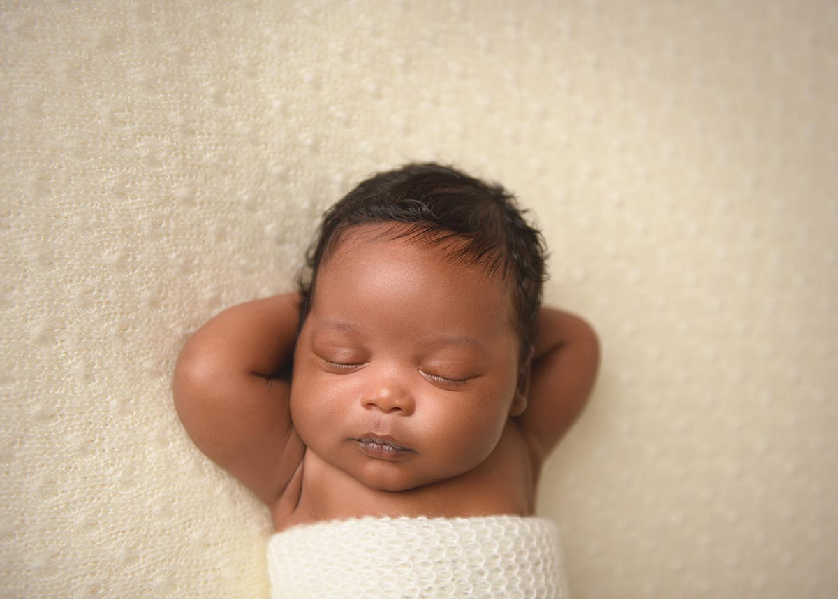 Infant baby sleeping peacefully on a blanket.