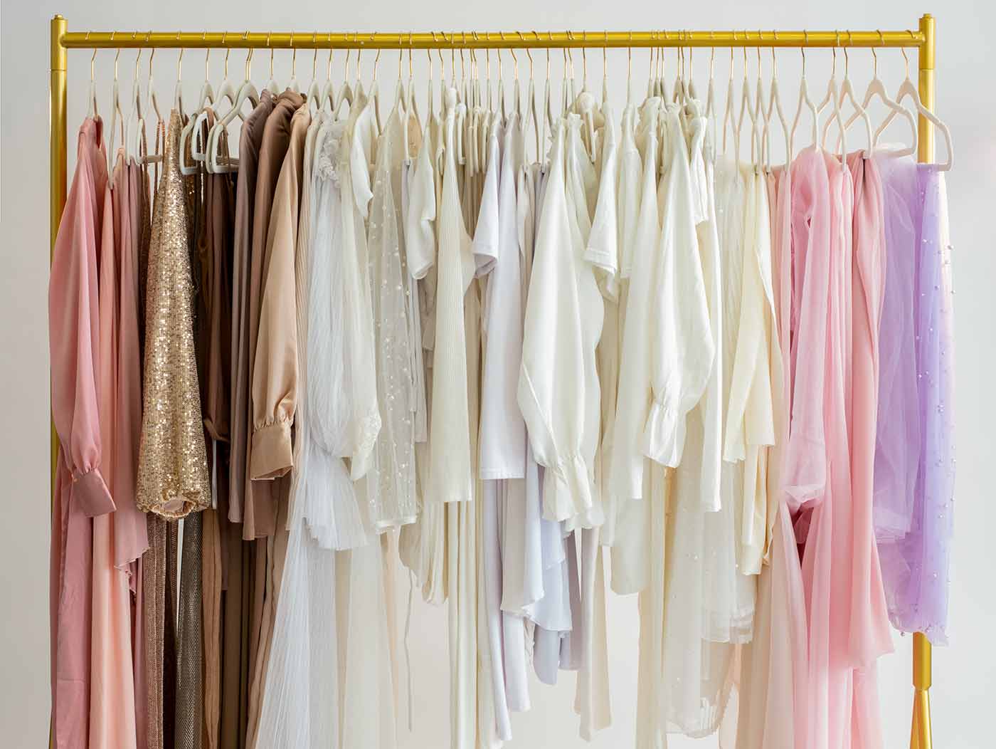 Garment rack showcasing a wide assortment of pregnancy dresses in a broad range of colors and textures.